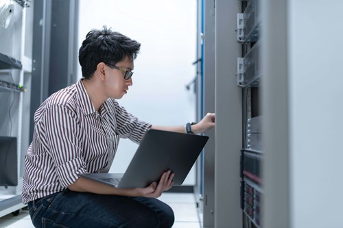 man kneeling down with his laptop 