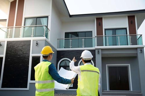 men in hard hats examining modern house 