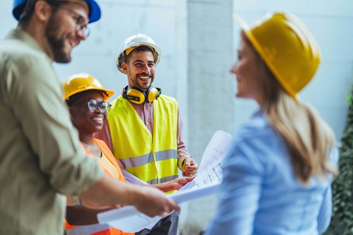 construction workers with hard hats smiling and laughing together 