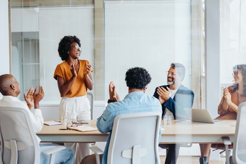 colleagues clapping in a meeting room